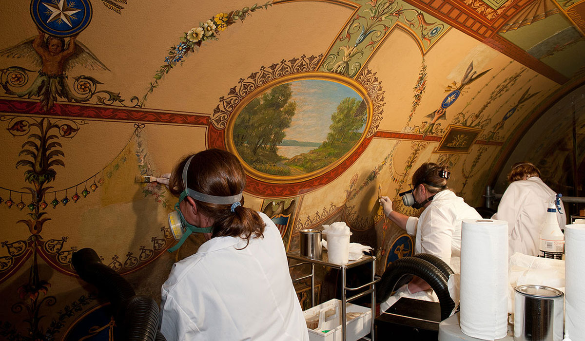 Workers restore painting