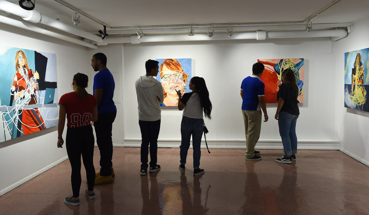 People looking at paintings in Salve Regina Gallery